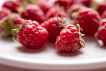 Fresh ripe raspberry with leaf on white plate, Summer fruit
