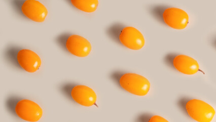 Sea buckthorn berries arranged on beige background, natural skincare concept.