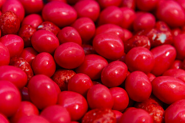 Dessert snacks strawberries in red chocolate. Many on the store counter. Top view of red chocolate balls with strawberries inside