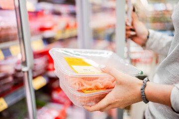 Girl Taking Pack Of Ground Meat From Supermarket Fridge With Hands In Close-Up