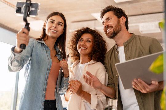 Startup team recording video content with smartphone gimbal in office - Powered by Adobe