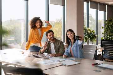 Business team taking selfie in modern office after successful project completion