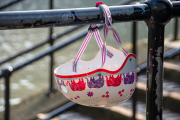 A girls helmet attached to the railing near the river