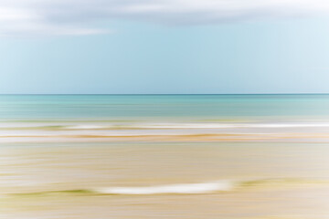 Softly blurred seascape with pastel tones and gentle horizontal lines evoking a dreamy atmosphere.