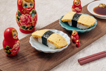 お寿司を見つめるマトリョーシカ