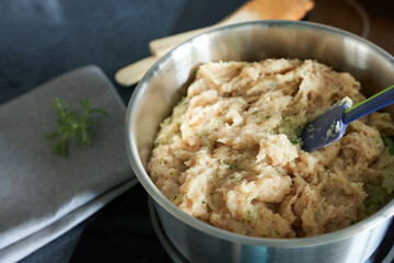 Homemade minced chicken in a saucepan on a black background. Diet meat.