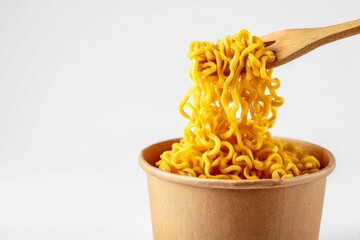 Yellow noodles are being lifted from a paper cup with a wooden fork