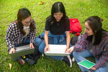 Three youth Asian female collage students working with assignment on laptop together in outdoor class campus