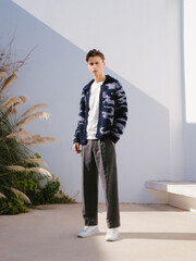 Stylish young man in a casual outfit posing outdoors with a modern vibe.