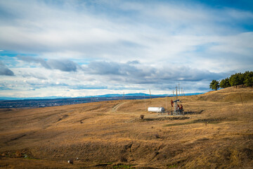 A single small oil well in the middle of a barren landscape