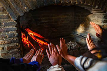Group of hands warming up by the fire