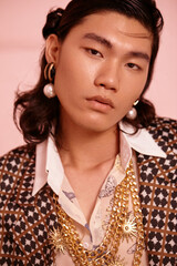 Stylish young man in ornate clothing with striking accessories.