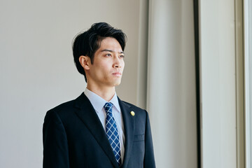 Fototapeta premium 遠くを見つめる20代の若い弁護士