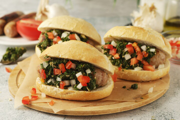 Choripan - bread with grilled sausages with chimichurri sauce, traditional Argentinian fast food dish