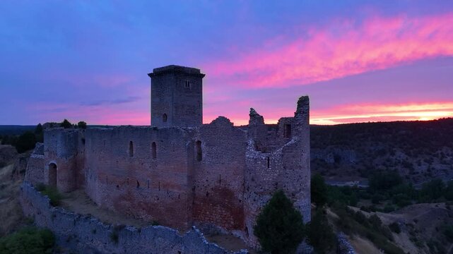 Aerial view from a drone of the sunset at the castle in the town of Ucero, in the Burgo de Osma region, Soria Province, Autonomous Community of Castile and Leon, Spain. Europe