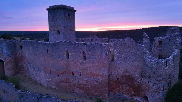 Aerial view from a drone of the sunset at the castle in the town of Ucero, in the Burgo de Osma region, Soria Province, Autonomous Community of Castile and Leon, Spain. Europe