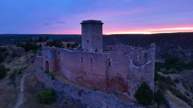 Aerial view from a drone of the sunset at the castle in the town of Ucero, in the Burgo de Osma region, Soria Province, Autonomous Community of Castile and Leon, Spain. Europe