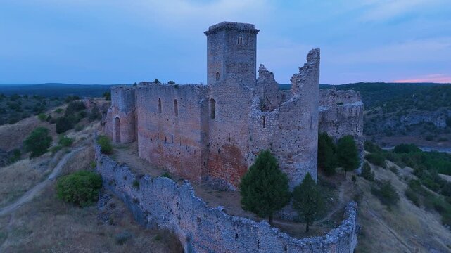 Aerial view from a drone of the sunset at the castle in the town of Ucero, in the Burgo de Osma region, Soria Province, Autonomous Community of Castile and Leon, Spain. Europe