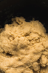 Nigerian Chin chin dough in a black mixing bowl, Raw chin-chinbeing mixed, process of making chin chin achomo or klenat