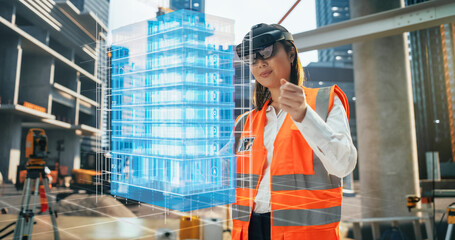 Japanese Female Architect Wearing an Augmented Reality Headset and Inspecting a Digital Hologram of a Building. Asian Civil Engineer Using a Software with Virtual Construction Plan and Interior Model