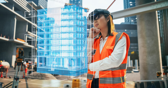 Japanese Female Architect Wearing an Augmented Reality Headset and Inspecting a Digital Hologram of a Building. Asian Civil Engineer Using a Software with Virtual Construction Plan and Interior Model