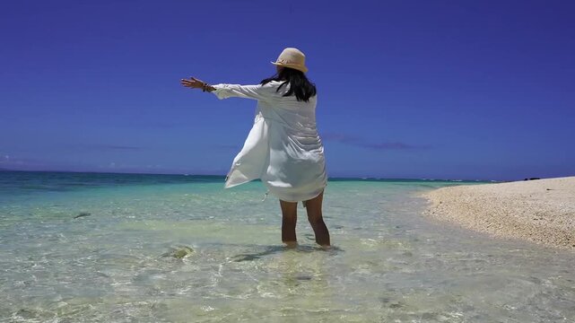 南国の美しい海辺で寛ぐ女性