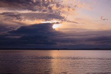 sunset over the sea, with dark moody clouds.