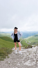 Fototapeta premium A young woman on top of a mountain is boldly pursuing her goal, filled with joy.