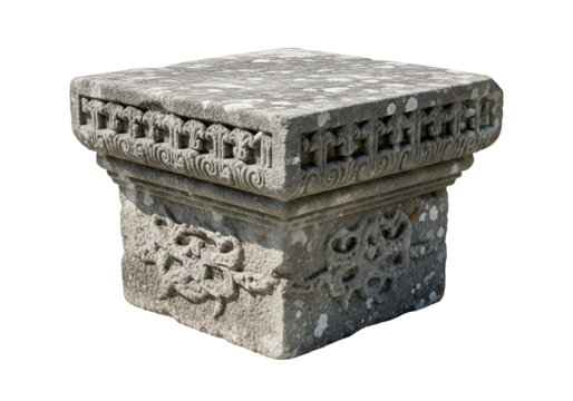 Ornate, square stone pedestal, carved with intricate floral and scrollwork designs, exhibits a muted gray tone and a weathered appearance against a pure black background.