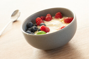 Bowl of yogurt with fresh raspberries, blueberries and honey, healthy breakfast