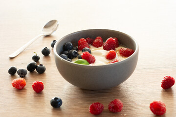 Bowl of yogurt with fresh raspberries, blueberries and honey, healthy breakfast