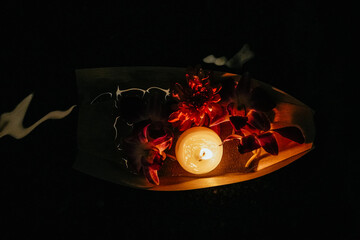 Small boat carrying a lit candle and vibrant flowers, gracefully floating on water, celebrating the...