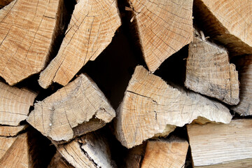 Large pile of firewood, cut of wood, dark texture group of objects close up