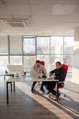 Two Caucasian men solve problems at work. 
