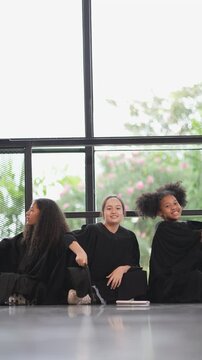 Girls of diverse ethnicities including Asian, White , African American&mdash;celebrate their graduation together in scool, wearing caps and gowns, smiling brightly as they share this proud and happy milesto