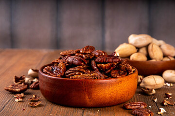 Pecans, peeled and shelled, whole and crushed into pieces. Candied caramelized and raw fresh pecans, autumn harvest, delicious snack, ingredient for baking, pies, cookies