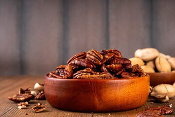 Pecans, peeled and shelled, whole and crushed into pieces. Candied caramelized and raw fresh pecans, autumn harvest, delicious snack, ingredient for baking, pies, cookies