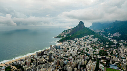 Aerial view of Rio de Janeiro coastline with Leblon, Ipanema and Dois Irmãos Mountain, showing city buildings, sandy beach and Atlantic Ocean, captured by DJI Mavic 3 drone