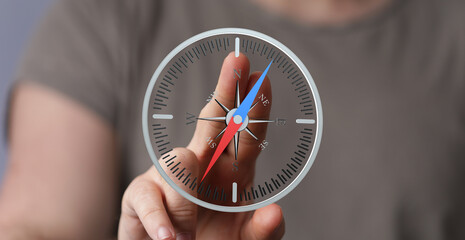 Close-up of a hand interacting with a digital compass, illustrating direction and guidance.