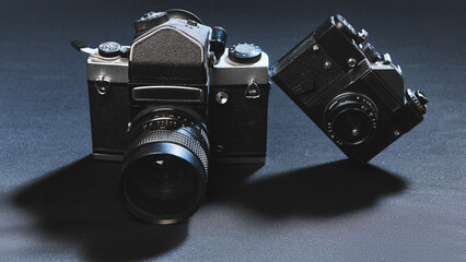 Pair of classic analog photo cameras on dark surface in retro style. Concept of technology history,...