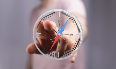 Person's hand interacts with a digital compass, illustrating navigation, direction, and guidance.
