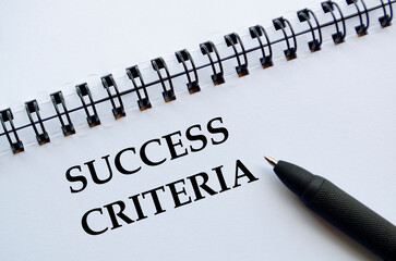 A professional notebook with pen showing success criteria concept