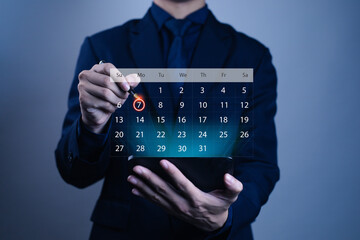 Businessman's hand pointing at digital calendar with highlighted date on transparent interface,...