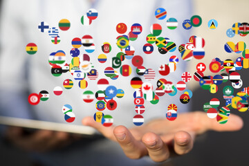 A hand holds many flags, symbolizing global connection and international collaboration.