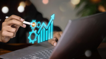 Businessman using laptop with growth chart and gear icons, digital business process automation and financial success concept