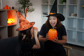 Halloween joy: mother and daughter sharing excitement with pumpkins and festive hats