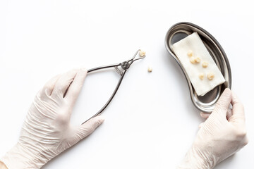Dentist hand in white medical glove is holding dental equipment tools for teeth care on white...