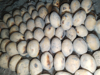 Traditional Indian food litti roasted on coal fire, showing baked dough balls filled with sattu...
