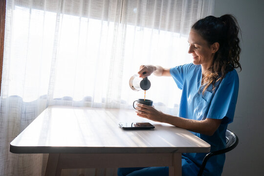 Female doctor pouring coffee at home before work