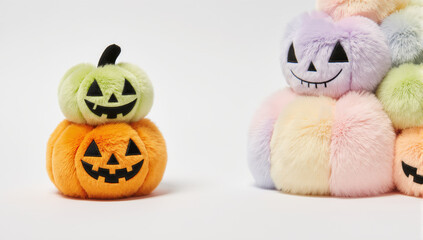 Stacked plush pumpkin soft toy Halloween pastel color smiling face isolated on white background playful and cute decoration cozy and cheerful vibe